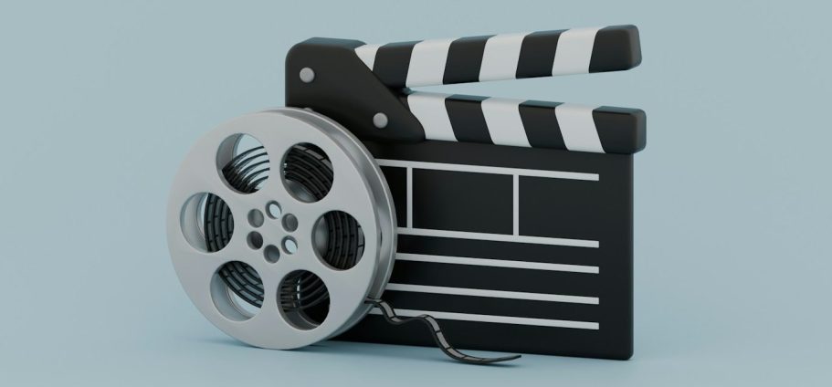 Filmklappe und Filmrolle auf einem hellblauen Hintergrund.